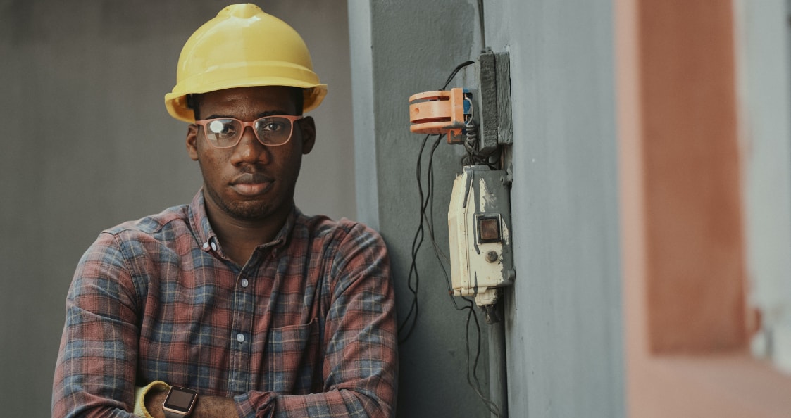 un technicien portant un casque jaune à côté d'un appareil électrique