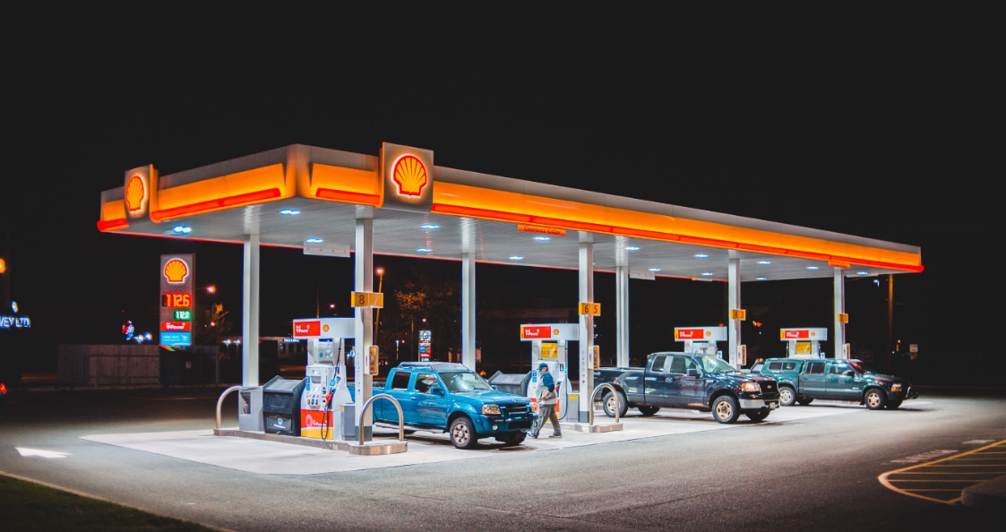 des véhicules qui font le plein de carburant dans une station essence de nuit