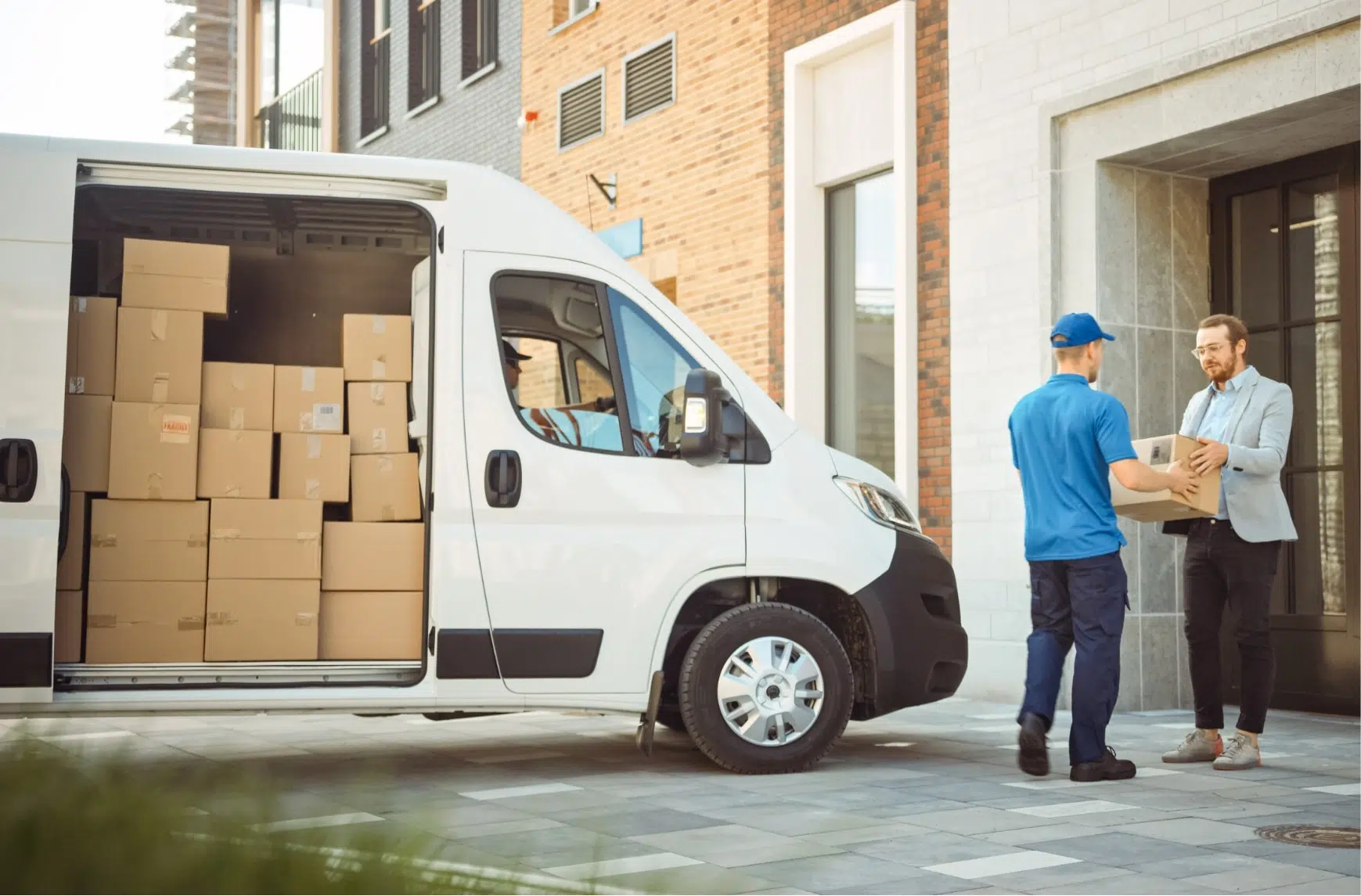 A deliveryman gives parcels to a man.